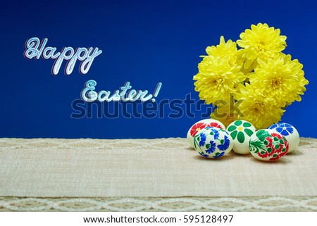 Yellow flowers and painted in hand-made Easter eggs on a blue background with the inscription "Happy Easter"