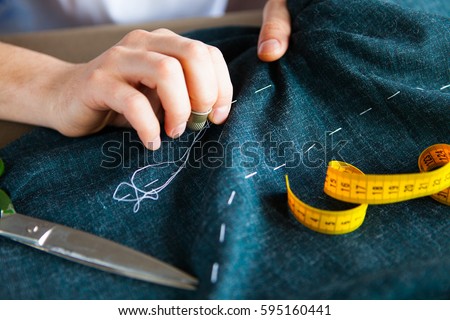 Tailor man working in his tailor shop, Tailoring, close up Royalty-Free Stock Photo #595160441