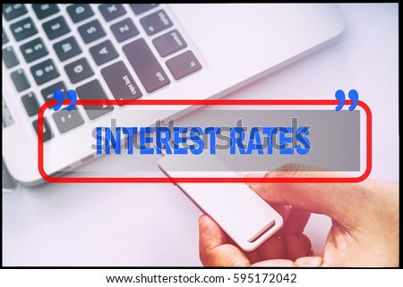Hand and text  "INTEREST RATES" with vintage background. Technology concept.