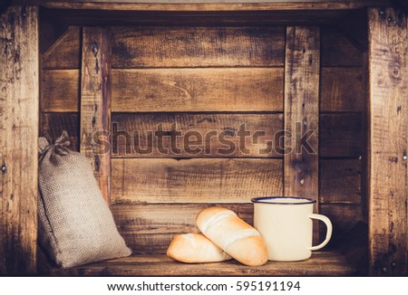 Cup and burlap with coffee bean sack and bread on wooden window-shaped box