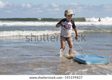 Boy surfing on a beach of Brazil, North Coast of Sao Paulo State.