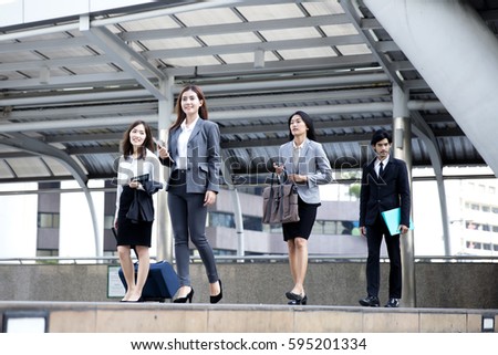 Business people walking together on street and smiling with friends


