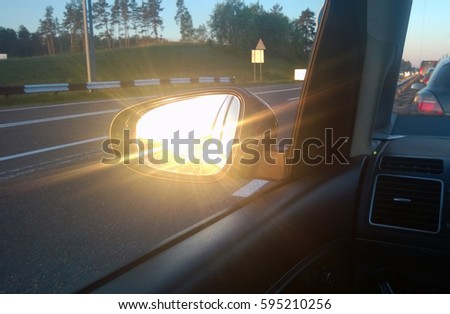 View from a side mirror of a car .Sunset on the road. Cars on the road heading towards the goal of the trip. tourism And Race car.