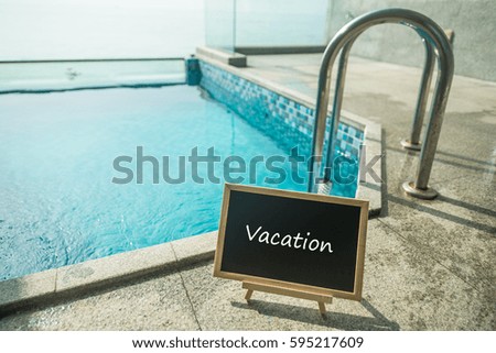 Blackboard with text vacation and swimming pool as a background.