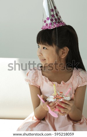 Birthday girl with cupcake looking sideways