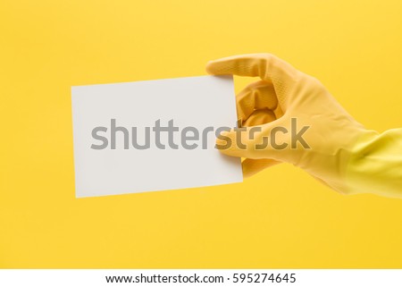 Hands in yellow cleaning gloves with blank white card