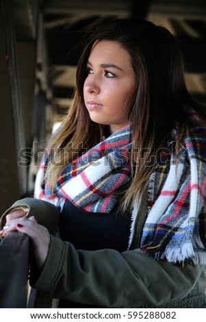 brunette women wearing a jacket and scarf looking out