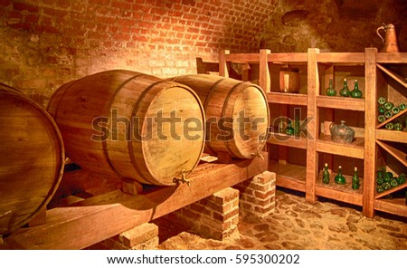 Beautiful photo of barrels with a wine in a cellar with a brick wall background. Vintage.