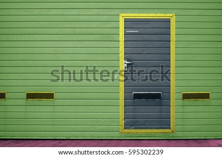 Green garage gate with ventilation grilles. Large automatic up and over garage door with inclusion of smaller personal door. Funny colorise. Multicolor background set