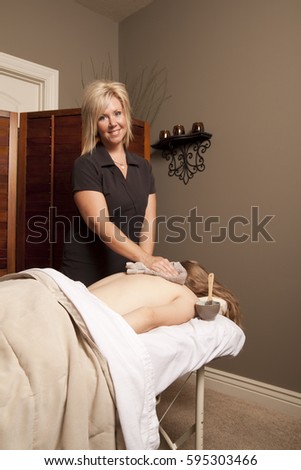 Massage therapy theme photo. Massage therapist massaging a female client.