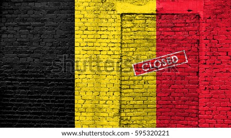Belgium flag on brick wall with bricked door and Closed sign