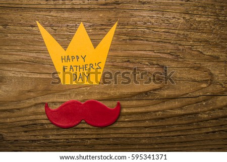 Happy fathers day card design, photo, image. yellow crown and red mustache on wooden table background. empty copy space for inscription. father's day idea, sign, symbol, concept. 