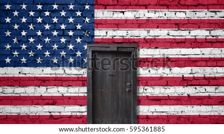 American flag on brick wall. Closed door in a wall