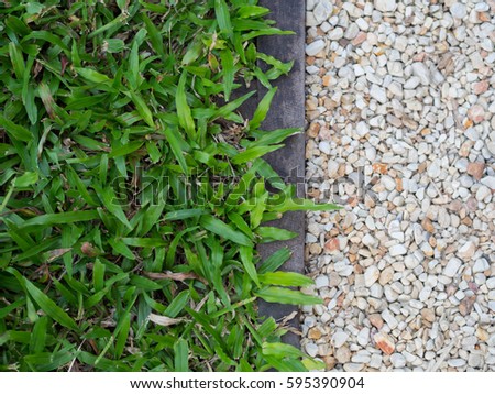 natural paving background texture with green grass and stone pebble separates with wood Royalty-Free Stock Photo #595390904
