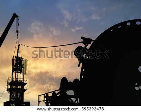 Silhouette image of coiled tubing workover rig unit with dramatic sky during sunset during well servicing the oil and gas industry