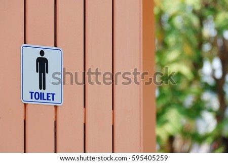 Toilet sign on wood wall with copy space wallpaper background