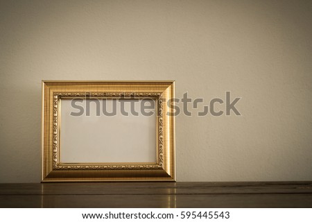 Gold photo frame on wooden