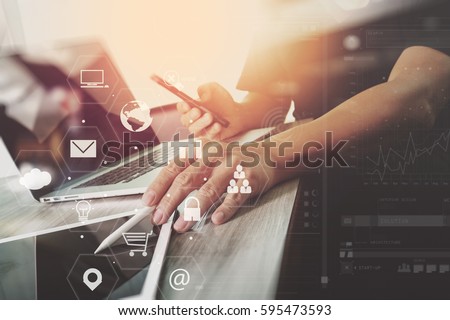 businessman working with laptop computer and digital tablet and smart phone and book and document on wooden desk in modern office with virtual icons interface