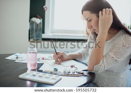 girl painter in white dress draws paints