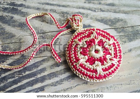 Handmade accessories in ethnic style on wooden table. Crochet homemade things. Crochet pattern. Handicraft manufacturing.