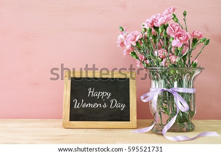 International women day concept. Bouquet of Carnation flowers in the glass vase on wooden table