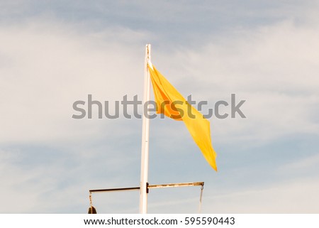 Yellow or orange flag floats in the sky