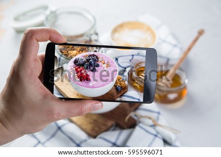 Taking photos of breakfast to phone. Social media concept. Sharing healthy food photos