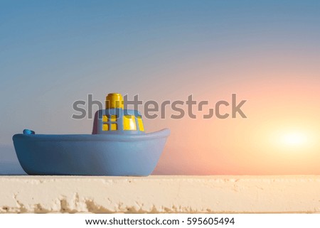 Toy ship on a blue sky background with sunlight