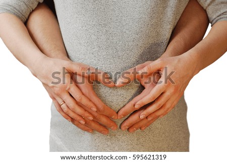 Happy young couple showing heart on belly of pregnant wife isolated on white background
