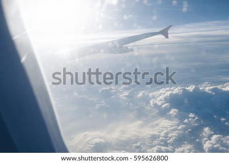 Airliner wing in sky with sun, Luminous glow in clouds, Background airplane, Air transport concept, Flight over clouds, Symbol air travel, Wing airliner in sky with sun