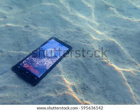 Mobile phones on the sand under the sea water.