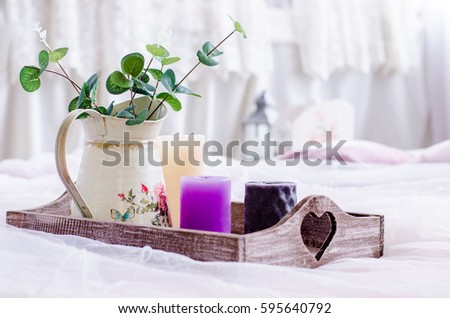 Interior decor. Tray with a vase and colored candles on a gentle white background. Royalty-Free Stock Photo #595640792