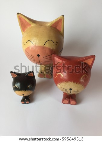 two wooden brown and one black cats as home decoration isolated on white