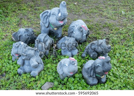 Cute elephant clay doll on the green grass ground.