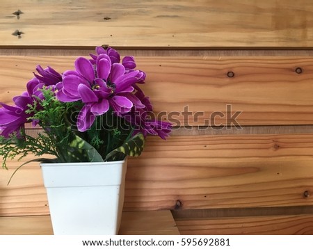 Colorful of Plastic flower in a white plastic pot on the shelf of Old Wooden natural color wall vertical vintage wood surface wood for background usage
