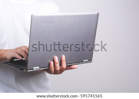 Hand holding laptop on white background