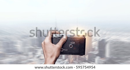 Man taking photo with vintage camera . Mixed media