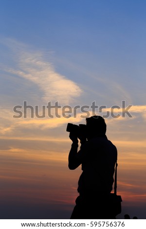 Silhouette of photographer on sunset.