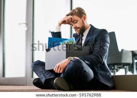 Fired from work. Sad dismissed businessman sitting outside the office after losing his job Royalty-Free Stock Photo #595762988