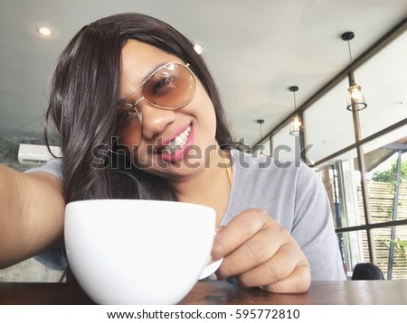 Woman taking a selfie with coffee cup