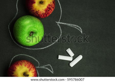 Apples are red and green on the chalk Board. Eye-catching, bright composition. Closeup, top view