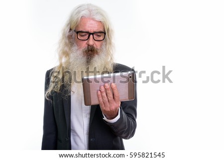 Studio shot of senior bearded businessman using digital tablet