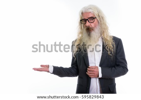 Studio shot of senior bearded businessman showing something