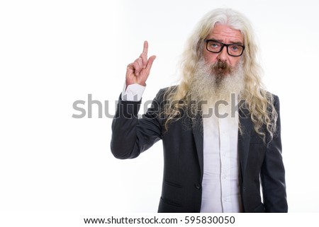 Studio shot of senior bearded businessman pointing finger up