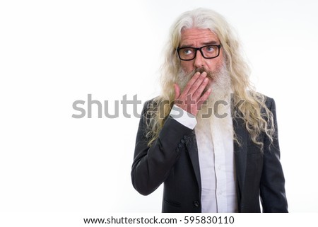 Studio shot of senior bearded businessman thinking while looking shocked