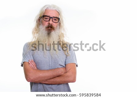 Studio shot of senior bearded man wearing eyeglasses with arms crossed