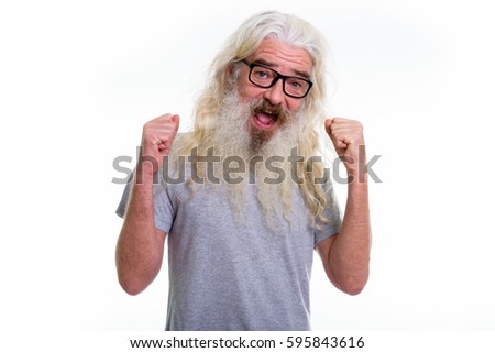 Studio shot of happy senior bearded man smiling and looking excited while wearing eyeglasses