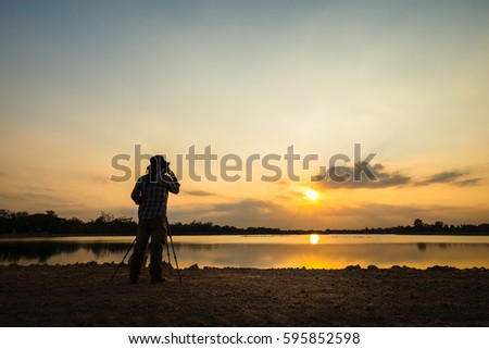 Silhouette of a photographer shooting sunset scene