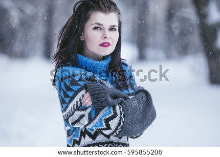 Beautiful young woman dressed warmly in winter Park in the fresh frosty air