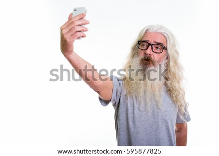 Studio shot of senior bearded man taking selfie picture with mobile phone